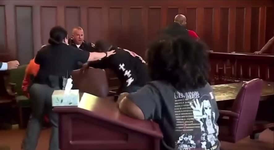 Cover for Brothers attack their mother’s killer in court.