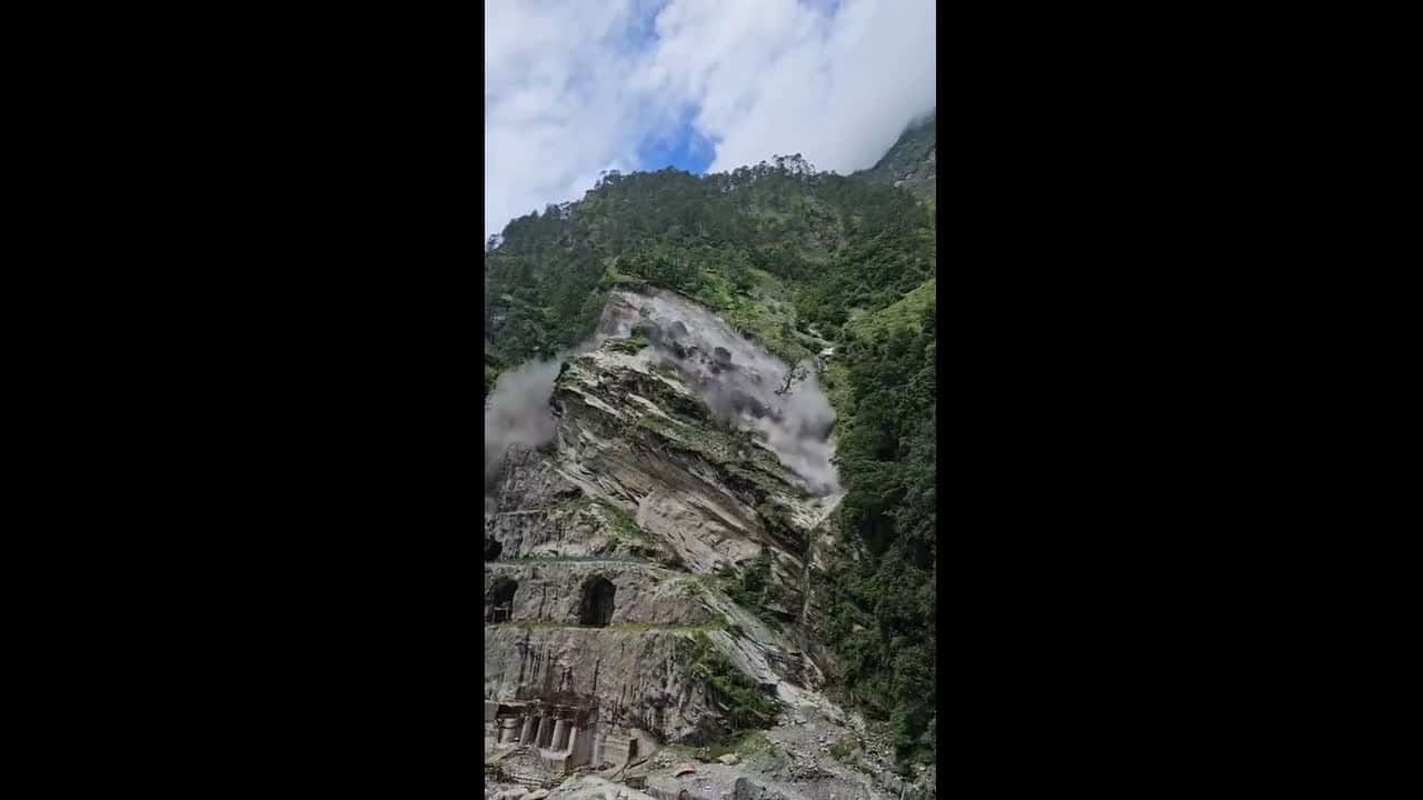 Cover for Onlookers scatter as landslide crashes down mountainside in India