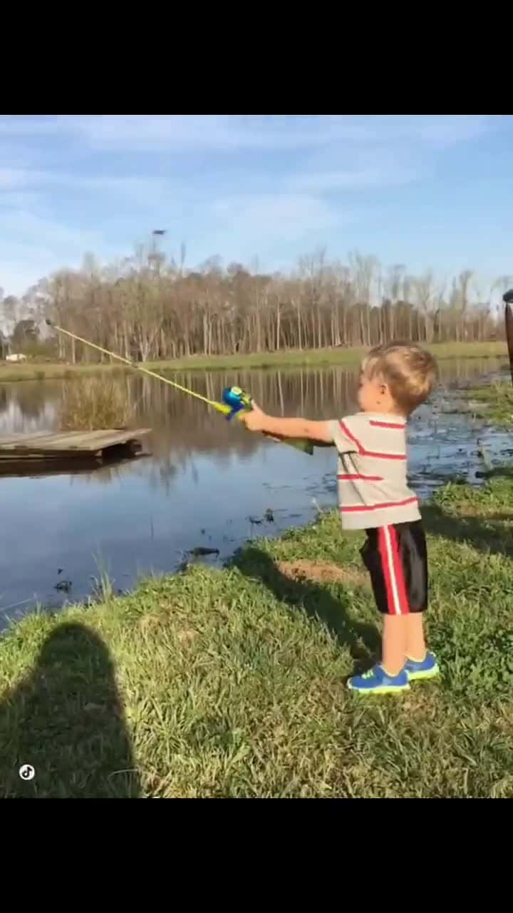 Cover for Toddler catches a fish with a toy rod.His father does not intervene, he wants everything to be under his control. #TooFunnyToScroll