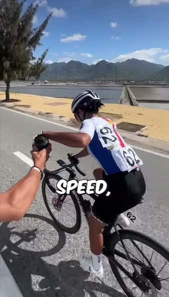 Cover for She is holding onto a water bottle to gain speed and propelling herself forward with it. This is illegal in bike races but typically overlooked. They can get disqualified but they usually just receive a time penalty.